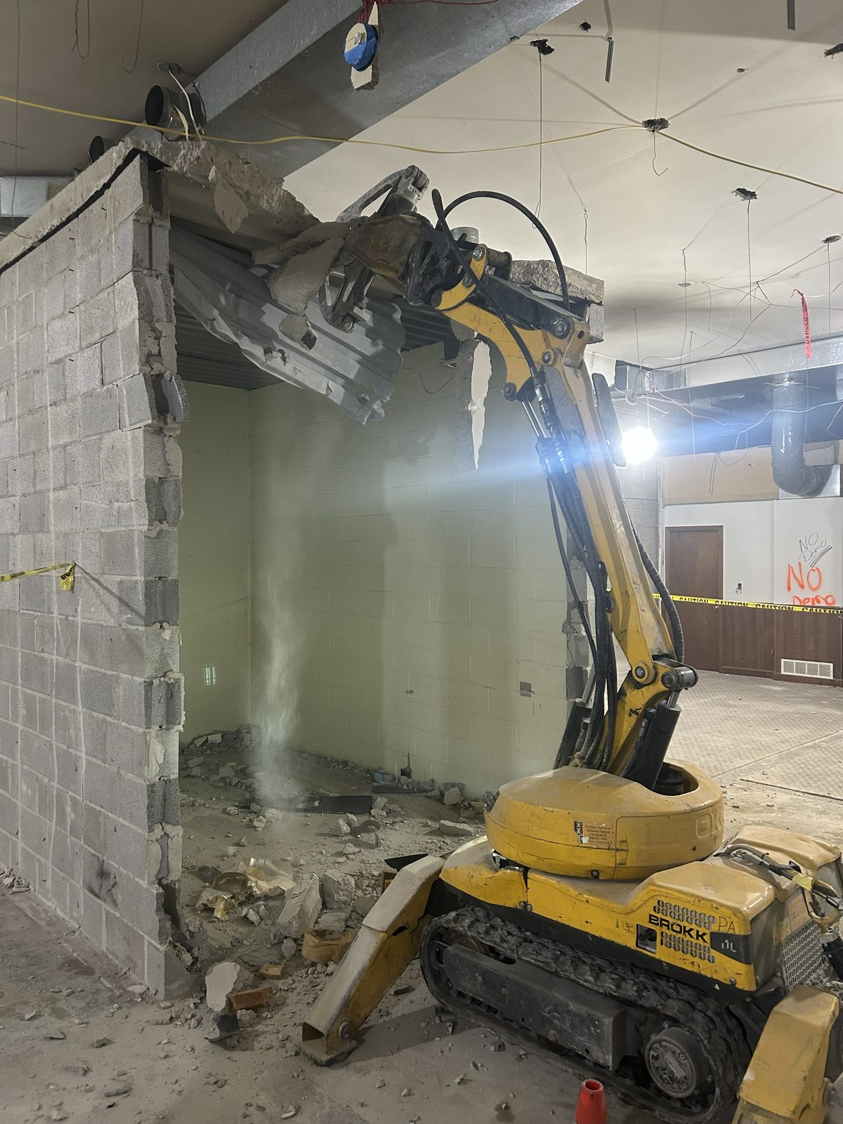 RETRO’s BROKK® remote-controlled machine pulling down a concrete block wall and metal deck inside a building
