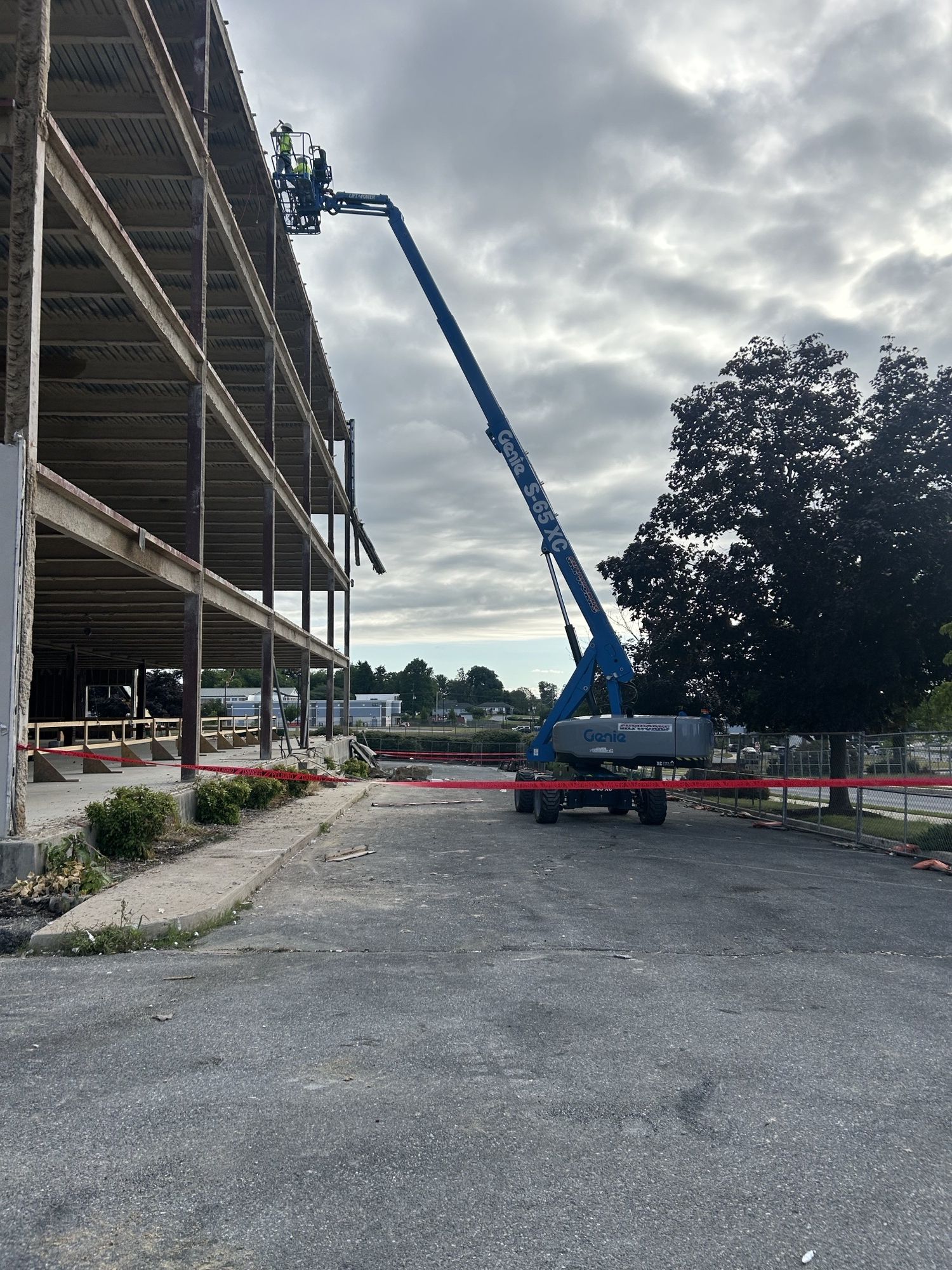 RETRO crew on a boom lift working at the edge of a multistory building stripped to its steel frame and floor decks